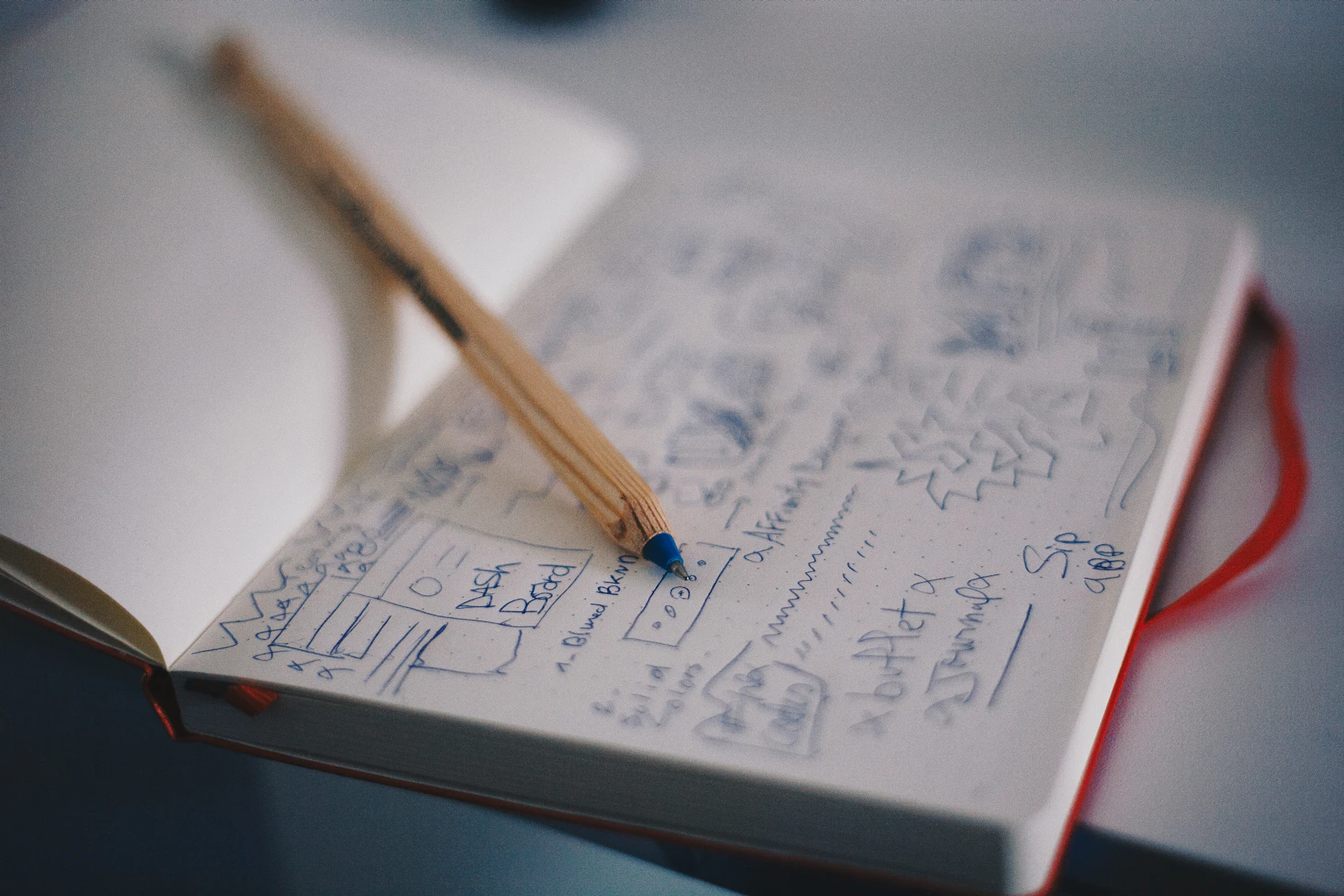 Pencil resting on a notebook filled with small planning sketches and annotations.